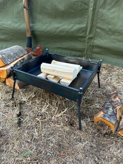 Wood splitter with logs and green tarp in the background
