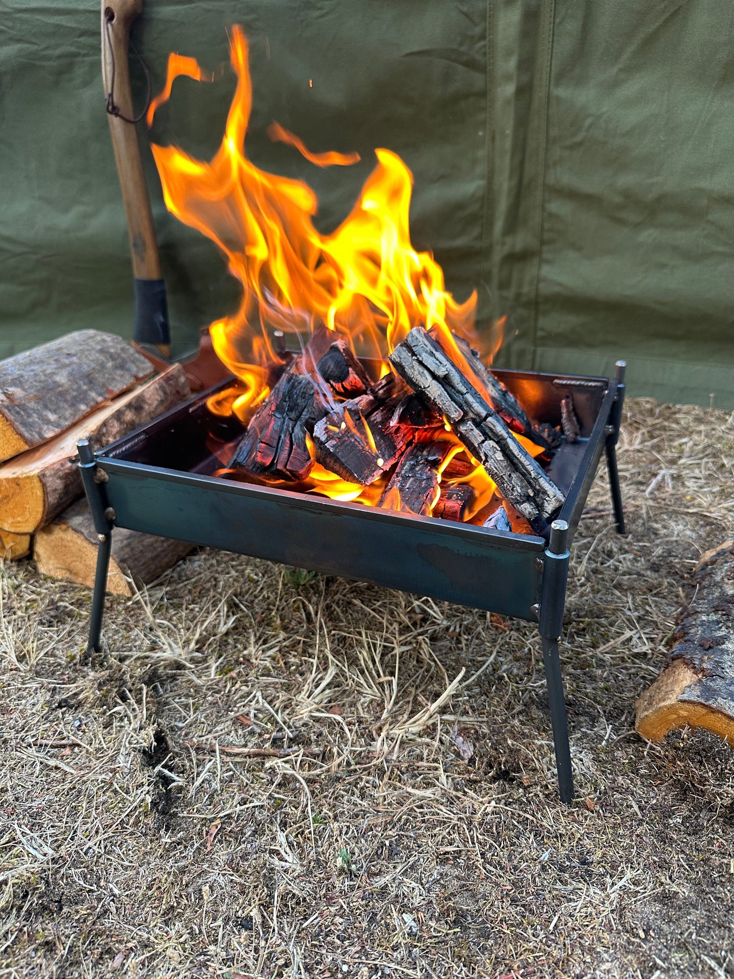 Fire pit with flames and wood on a natural ground surface