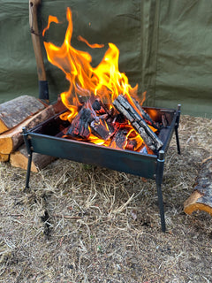 Fire pit with flames and wood on a natural ground surface