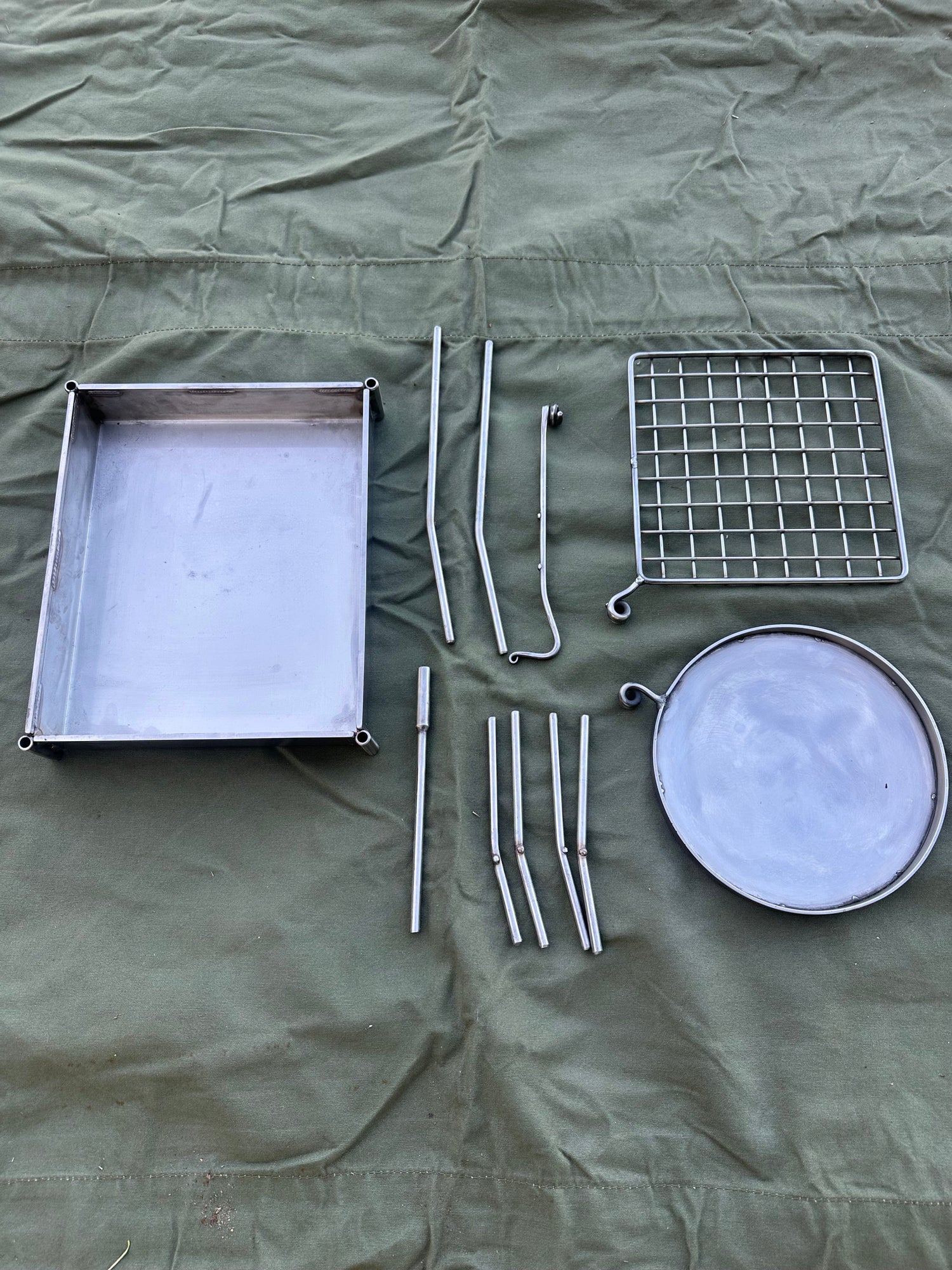 Collection of metal kitchen utensils on a green fabric background